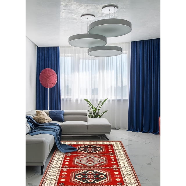 ECARPETGALLERY 100% Wool Traditional Indoor Area Rug with bold geometric Persian Kazak-inspired patterns in red, black, and cream, placed in a modern living room with a light gray sectional sofa, blue and beige pillows, blue throw, sheer white curtains, dark blue drapes, a red circular floor lamp, and three large round ceiling lights. This wool rug is also suitable for adding warmth and style to bedrooms or dining rooms.