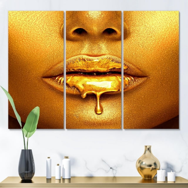 Designart Gold Paint Drips From Sexy Woman Lips Canvas Wall Art showing gold paint dripping from lips on premium cotton canvas with gallery-wrapped edges, displayed above a marble console table with black and gold vases and white candles, suitable for modern home décor.