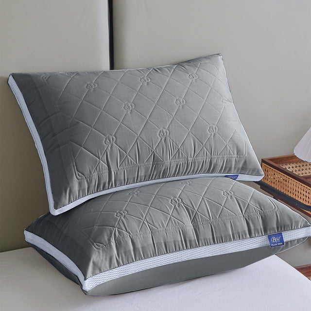 Styesk Hotel-Grade Bed Pillow in grey, featuring a soft and supportive polyester fiber fill. The pillow has a quilted design with floral stitching and strong piping along the edges for durability. Suitable for back, side, and stomach sleepers, it is made with skin-friendly cotton fabric. Displayed on a bed with a neutral background.
