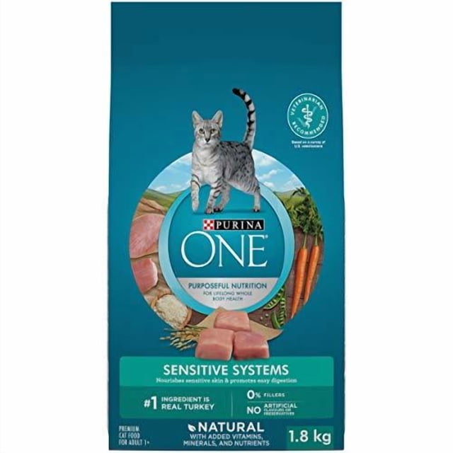 Purina ONE +Plus Sensitive Systems Turkey dry cat food bag showing a gray tabby cat above the brand logo, with images of real turkey meat, carrots, and grains on a teal background, highlighting natural ingredients, prebiotic fibre for digestive health, and immune support in a 1.8 kg package.