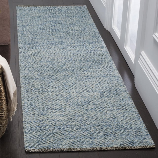 Safavieh Natura Eanna Geometric Area Rug, ivory and light grey, 6' x 9', hand-woven with soft, lustrous yarns forming a textured mosaic pattern with oversized loops, shown as a runner on dark hardwood flooring beside white paneled doors and a brown sofa with a beige throw, ideal for casual or beach house style interiors.