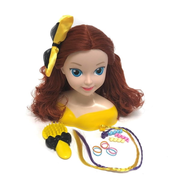 Wiggles Emma - 8" Styling Head with Painted Eyes featuring long, soft red hair with a yellow and black bow on the left side. Comes with a yellow brush with black bow handle, two clip-in braid extensions in purple and yellow, three pastel spiral hair accessories, and six multicoloured hair ties on a white background.