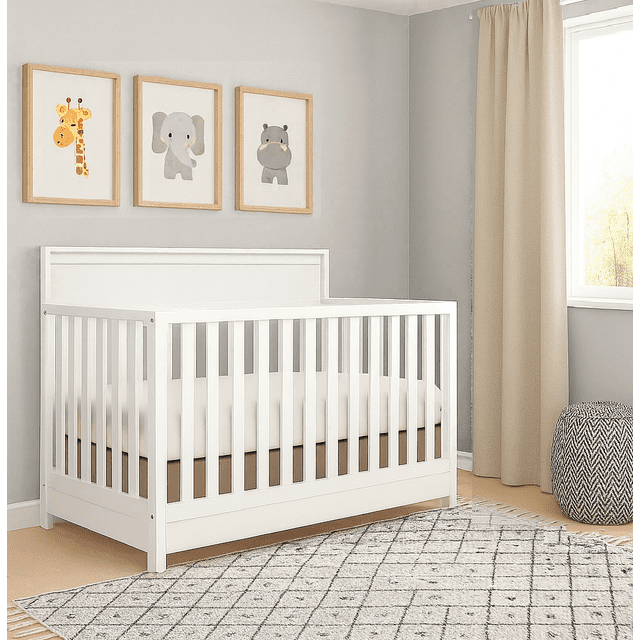 Concord Baby Brady Lit de Bébé 4-en-1 avec Tiroir en Blanc, Ensemble dans une Chambre de Bébé avec Murs Gris Pâle et Rideaux Beiges. le Lit de Bébé Présente des Lattes Verticales, une Tête de Lit Unie et un Grand Tiroir de Rangement sous le Lit de Bébé avec Deux Compartiments pour Organiser les Essentiels pour Bébé. Au-Dessus du Lit de Bébé, Trois Imprimés d'Animaux Encadrés d'Une Girafe, d'Un Éléphant et d'Un Hippopotame. un Tapis à Motif Gris et Blanc Couvre le Plancher, avec un