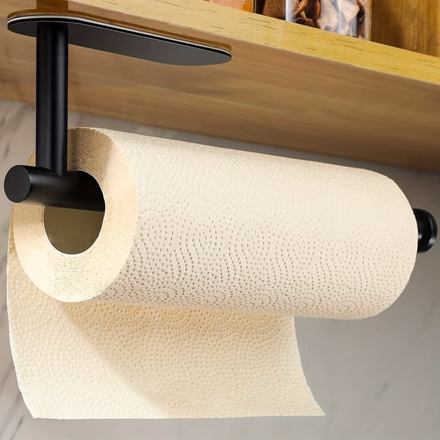 1pc self-adhesive paper towel holder under cabinet for kitchen or bathroom, made of stainless steel with a wall-mounted design. Ideal for kitchen organization, the holder is shown installed under a wooden cabinet, holding a roll of beige paper towels.