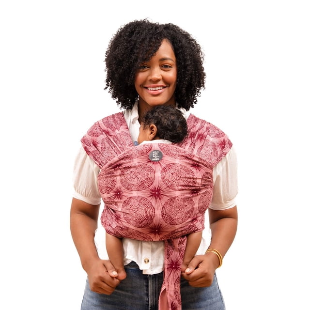 MOBY Wrap Baby Carrier - Evolution Wrap for Newborns & Infants in red patterned viscose and cotton knit fabric, worn front-facing with a baby held close to the chest, featuring a one-size, breathable, stretchy wrap tied securely around the wearer’s torso and shoulders for hands-free carrying.