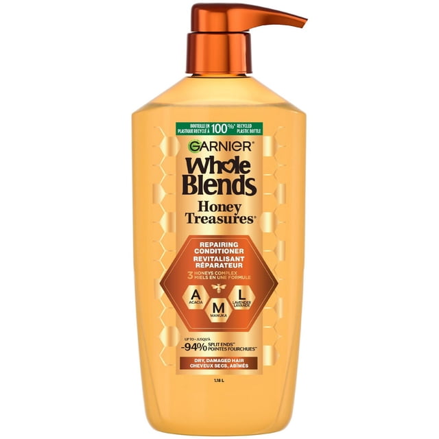 Garnier Whole Blends Honey Treasures Repairing Conditioner in a 1.18 L honey-colored bottle with an orange pump, featuring a 3 honeys complex of Acacia, Manuka, and Lavender to repair dry, damaged hair by reducing split ends, breakage, and dryness.