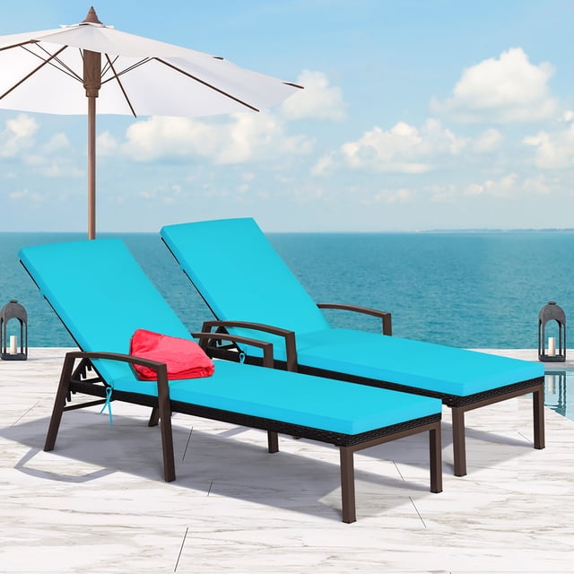 Costway 2PCS Patio Rattan Lounge Chair Chaise Recliner with turquoise cushions, designed for outdoor use with adjustable backrests and sturdy steel frames. Ideal for patios, poolside, or gardens, the chairs are shown on a marble patio overlooking an ocean view, with a white umbrella providing shade.