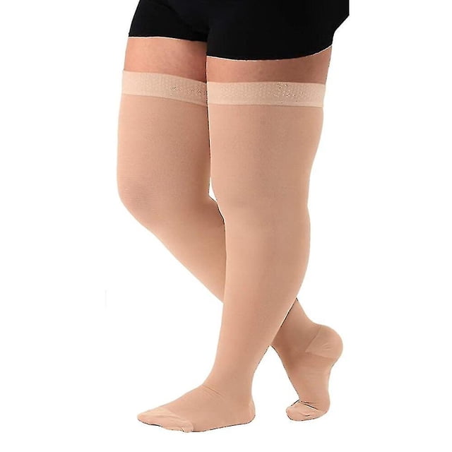 Bas de compression Médicaux 5TG extra Larges 34-46 mmHg pour Femmes, Illustrés en beige, avec un design à Bout Fermé et une Longueur Cuisse. Fabriqués à Partir de 70 % de nylon et 30 % d'Élasthanne, Ces Bas Comprennent une Bande en silicone sur la Cuisse pour Empêcher le Glissement, une construction Sans Coutures pour le Confort et des Zones Renforcées des Orteils et du Talon pour la Durabilité. Conçus pour les Varices et un Soutien de Pression Graduée, Ils Offrent une Extensibilité Quatre Directions