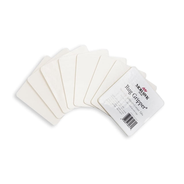 Mohawk Home Rug Corner Gripper Rug Pad 8 Piece Set in white, showing eight square adhesive non-slip corner tabs fanned out on a white background, designed to keep indoor area rugs secure on hard floors without added bulk or height.