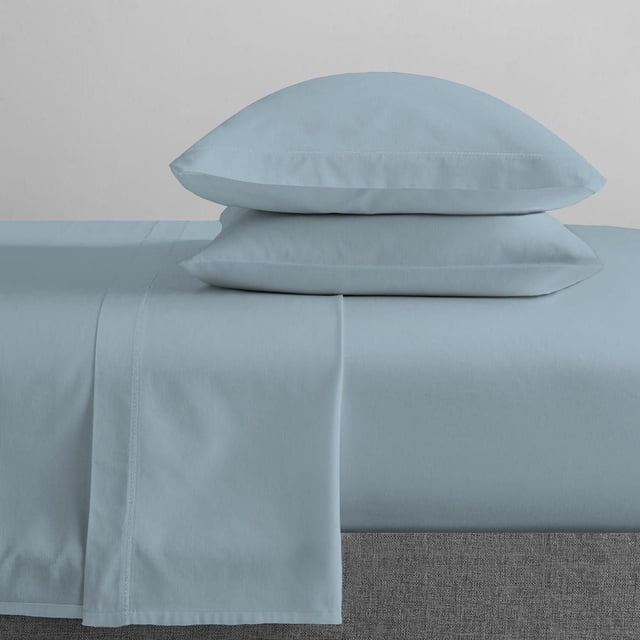 Johnson Home 200 TC Bed Sheet Set - Organic Cotton Sheets in light blue, showing a fitted sheet, flat sheet, and two pillowcases stacked on a grey bed base, made from breathable, smooth organic cotton for year-round comfort and durability.