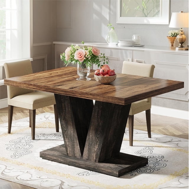 Fnova 47.24" Rectangular Farmhouse Dining Table with a rustic brown-black finish, featuring a 1.57"-thick engineered wood tabletop and a unique V-shaped frame. Designed to seat 4 people, this table is ideal for small spaces, dining rooms, or cafes. It is waterproof, scratch-resistant, and easy to clean, with adjustable foot pads for stability on uneven floors. Shown in a bright dining room setting with decorative items on top.