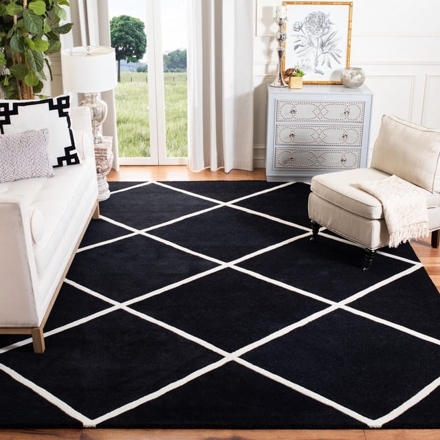 Safavieh Chatham Isaac Tapis à Losanges Géométriques, Tapis en Laine Noir Tufté à la Main avec Motif de Losanges Blancs et Hauteur de Poil Moyenne, Exposé dans un Salon Moderne avec Planchers de Bois Franc, sofa Blanc, Fauteuil beige avec Jeté, et Coffre Décoratif Gris avec Oeuvre Florale, Près de Grandes Fenêtres avec Rideaux Blancs et Vue Extérieure Verte, Idéal pour Ajouter Douceur et style Géométrique à la Déco Contemporaine de la Maison.