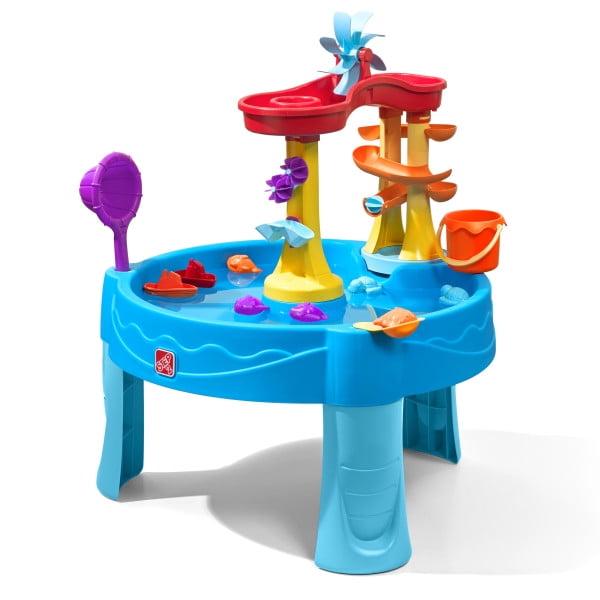 Step2 Archway Falls Water Table with a blue basin and four legs, featuring a red two-tier waterfall tray, yellow and orange ramps, blue and purple spinners, an orange bucket, and sea critter and boat toys that encourage cause and effect play and sensory exploration for toddlers.