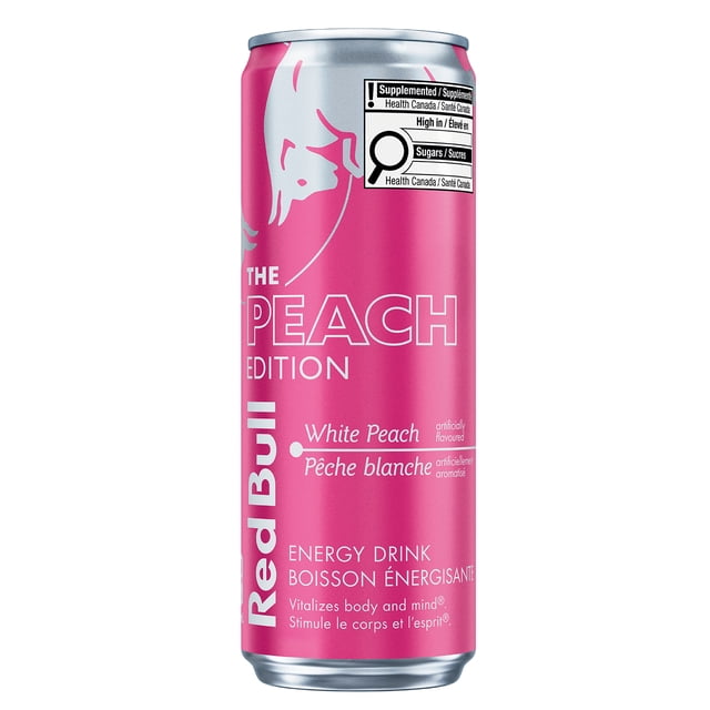 Red Bull White Peach 355ML energy drink can in bright pink with white text and Red Bull logo, labeled The Peach Edition with artificial white peach flavor, Canadian health warnings for high sugar and caffeine, vitalizes body and mind, often used for energy boost during work or travel.