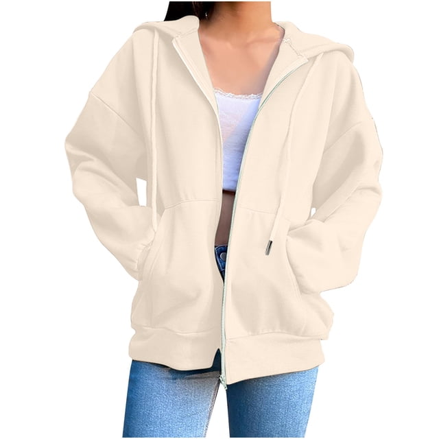 Timegard Vestes pour Femmes à Fermeture Éclair devant à Manches Longues Chandails à Capuchon Confortables avec Poches, Montré en Couleur beige Pâle Uni. le Chandail à Capuchon Présente une Fermeture Éclair avant, des Manches Longues et une Coupe Décontractée avec Deux Poches avant. Fabriqué en Tissu Doux, Extensible et Léger, Il Est Idéal pour l'Automne et les Temps Plus Frais. le Modèle l'Agence avec un Haut Blanc et des jeans Bleus, Mettant en Valeur Son style Décontracté et Polyvalent.