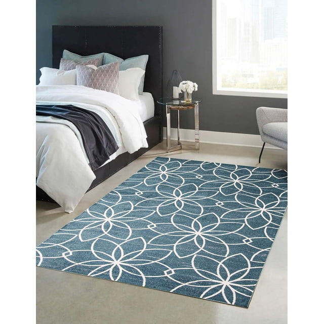 ECARPET washable floral area rug and runner in aqua with white floral pattern on low pile polyester, placed in a modern bedroom with dark upholstered bed, white bedding, glass side table, and grey walls, ideal for high traffic areas and easy vacuum cleaning.