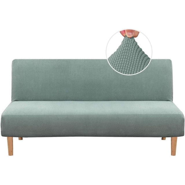 Armless Futon Cover Stretch Sofa Bed Slipcover Protector with elastic, textured high spandex small checks jacquard fabric in a sage green color. The slipcover is shown fitted on a futon with wooden legs, highlighting its snug fit and stretchable material. A close-up inset displays the textured jacquard pattern. Suitable for futons 68-85 inches wide, it protects against stains and wear, ideal for homes with children and pets. Machine washable for easy maintenance.