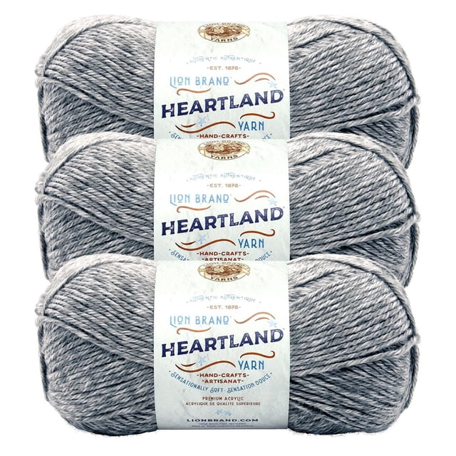 Lion Brand Yarn Heartland Yarn 3Pack featuring three skeins of worsted weight acrylic yarn in heathered light grey, each with a white label showing brand and product information, machine washable and suitable for knitting, crochet, and crafting projects.