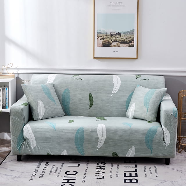1/2/3/4 Seater Elastic Sofa Covers Slipcover Settee Stretch Floral Couch Protector displayed on a two-seater sofa in a living room setting. The cover features a light grey base with a feather pattern in shades of white, green, and blue. Made from polyester fiber, it is stretchable, breathable, and designed to fit various sofa sizes ranging from 90 cm to 300 cm. The sofa is accessorized with matching cushion covers, and the background includes a framed wall art and a bookshelf.