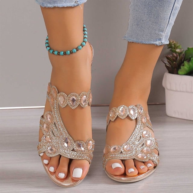 Cameland Women's Summer New Rhinestone Color Diamond One Line Thick Sole Fashion Wedge Sandals with sparkling rhinestone accents and a thick sole for added comfort. Designed with a flip-flop closure and round toe style, these sandals are ideal for casual indoor and outdoor wear. Perfect for pairing with swimsuits, shorts, or dresses for a stylish summer look. Shown styled with cropped jeans and a turquoise anklet.