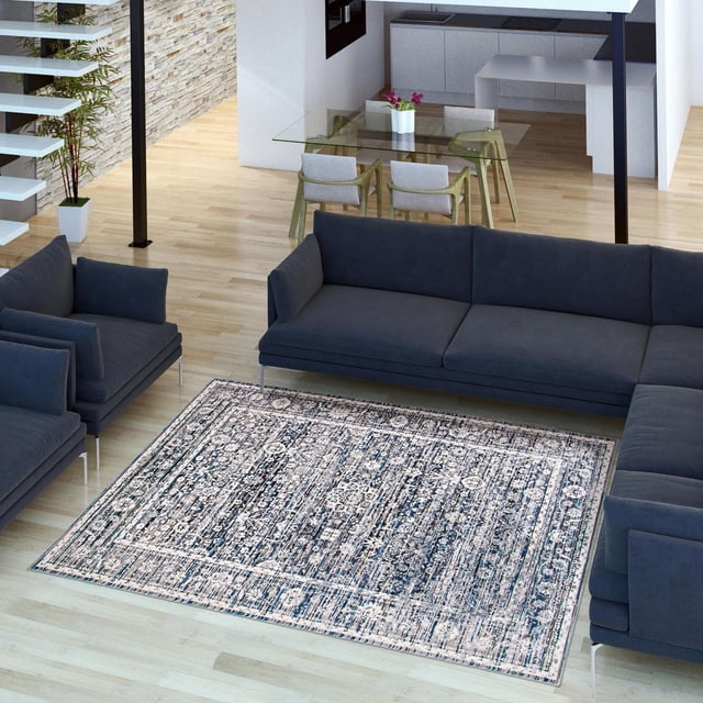 ECARPET Layla Crème, Tapis Gris sur Plancher de Bois Franc Clair dans un Salon Moderne avec Canapés et Fauteuils Gris Foncé, Présentant un Motif Abstrait Texturé Crème et Gris Fabriqué à Partir de Fil durable, Idéal pour Rehausser la Déco Intérieure Contemporaine.