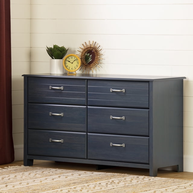 South Shore Ulysses 6-Drawer Dresser for Child in Blueberry with six spacious drawers and metal handles, placed against a white shiplap wall in a child's room, topped with a yellow clock, potted succulent, and round decorative mirror, resting on a beige patterned rug, suitable for organized storage in kids' bedrooms.