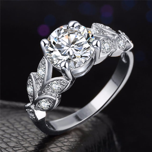 EGNMCR Rings Ladies Fashion Colorful Water Drop Oval Wedding Rings Gift Rings 1pc. This ring features a silver-tone alloy band with intricate leaf-like designs encrusted with small, sparkling crystals. A large, round-cut crystal centerpiece is set in a prong setting, creating a striking focal point. Suitable for weddings, engagements, or as a fashionable gift. The ring measures approximately 2 cm in size and comes in a single piece packaging.