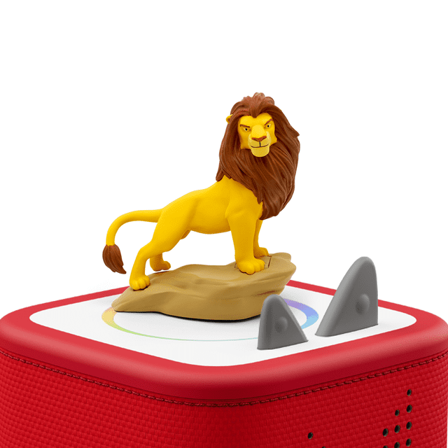 Tonies Audio Character - Disney Lion King with a yellow lion figurine featuring a brown mane standing on a tan rock, placed on a red and white Toniebox audio player with grey control ears, designed for educational electronics and screen-free kids entertainment.