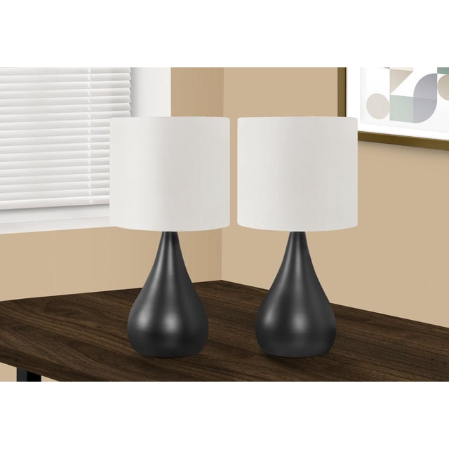Monarch Specialties Lighting set of 2 table lamps, 18 inches tall, with black metal teardrop bases and ivory linen tapered drum shades, placed on a dark wood table in a beige room corner near window blinds and geometric wall art, suitable for bedside or side table lighting.