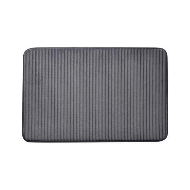 Mainstays Memory Foam Bath Mat in dark grey with ribbed texture, 20 by 30 inches, made of soft, absorbent polyester with cushioned memory foam and non-slip backing, suitable as a bathroom rug for stepping out of the shower or sink area.