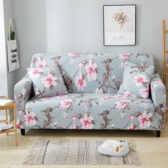 Housses de Sofa Élastiques pour 1/2/3/4 Places Slipcover Protège-Canapé Extensible à Motif Floral dans une base Gris Pâle avec Motifs Floraux Rose et Blanc. Fait de Fibre de polyester, Cette Housse Extensible et durable Convient aux sofas de 90 cm à 300 cm de Taille. Idéal pour Protéger les sofas contre les Taches, les Poils d'Animaux et l'Usure, Il Est Montré dans un Décor de Salon avec un Mur Gris Pâle, une Oeuvre Florale Encadrée et une Petite table d'Appoint en Bois.
