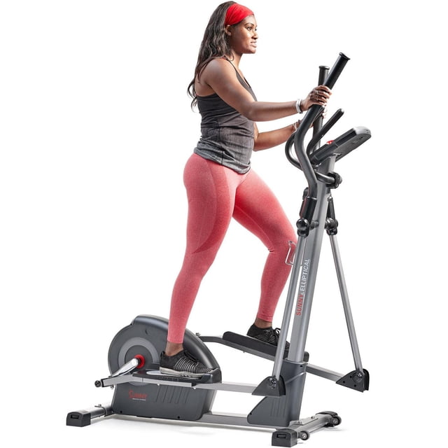 Sunny Health & Fitness Elite Interactive Series Exercise Elliptical SF-E320047 shown in side profile with a person exercising. The elliptical features a gray frame with black and red accents, dual handlebars with heart rate sensors, and a digital performance monitor. The user wears a black tank top, pink leggings, and black athletic shoes. This home elliptical offers 12 levels of magnetic resistance and Bluetooth connectivity for syncing with the SunnyFit® app for real-time fitness tracking and customized workouts.