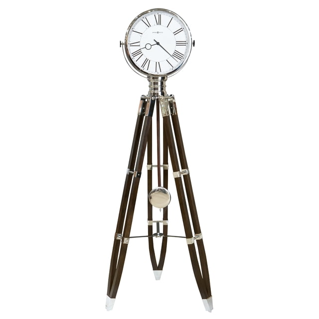HOWARD MILLER CHAPLIN TRIPOD WOOD FLOOR CLOCK 615070, a decorative grandfather clock with retro Hollywood-inspired styling. Features include a polished chrome bezel, black coffee-finished hardwood tripod base with chrome accents, a white dial with black Roman numerals, and quartz movement with triple-chime Harmonic options for Westminster or Ave Maria chimes.