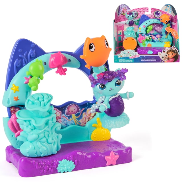 Gabby's Dollhouse: The Movie, Mercat's Aquarium Balcony playset with a purple base and turquoise cat-ear shaped balcony frame, featuring a mermaid MerCat figure with a purple tail and pearl necklace, an orange fish toy, and sea-themed accessories like starfish and coral, suitable for children ages 3 and up for imaginative dollhouse play.