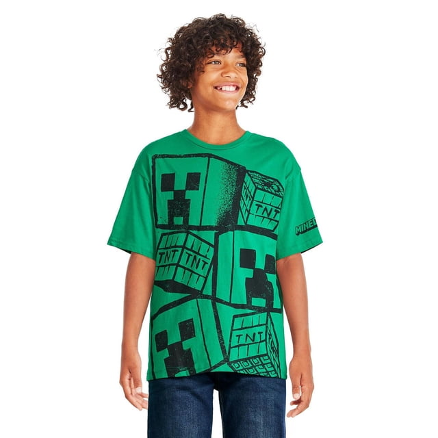 Minecraft Boys' Short Sleeve Tee in green jersey knit featuring black Creeper and TNT block graphics on the front, classic crew neckline, short dropped sleeves, and straight hem, paired with dark blue jeans for casual wear.