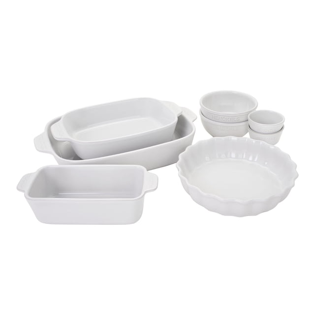 HENCKELS Ceramic 8 Piece Bakeware Set in white, featuring a 13 x 10-inch rectangular dish, 10 x 7.5-inch rectangular dish, 8.3 x 4-inch loaf pan, two 22-ounce universal bowls, two 7-ounce ramekins, and a 9.5-inch scalloped pie dish. Made of handmade stoneware with a highly scratch-resistant vitreous glaze, this set is oven safe up to 572°F, microwave, freezer, and dishwasher safe. Designed for durability, thermal shock resistance, and moisture resistance, the pieces stack snugly for compact storage. Sustainably made in Portugal using an energy-saving firing process.