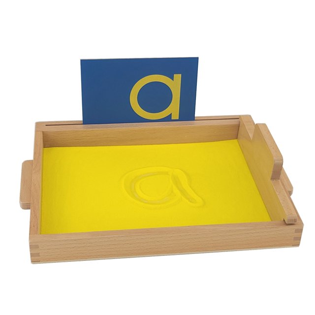 IFIT Montessori Sand Tracing Tray, Montessori Language Materials. A wooden tray measuring 34 cm x 25 cm x 3.5 cm, filled with yellow sand, designed for freehand tracing of letters and numbers. Includes a smoothing tool and a blue card with a yellow lowercase 'a' for reference. Sandpaper Letters are sold separately.