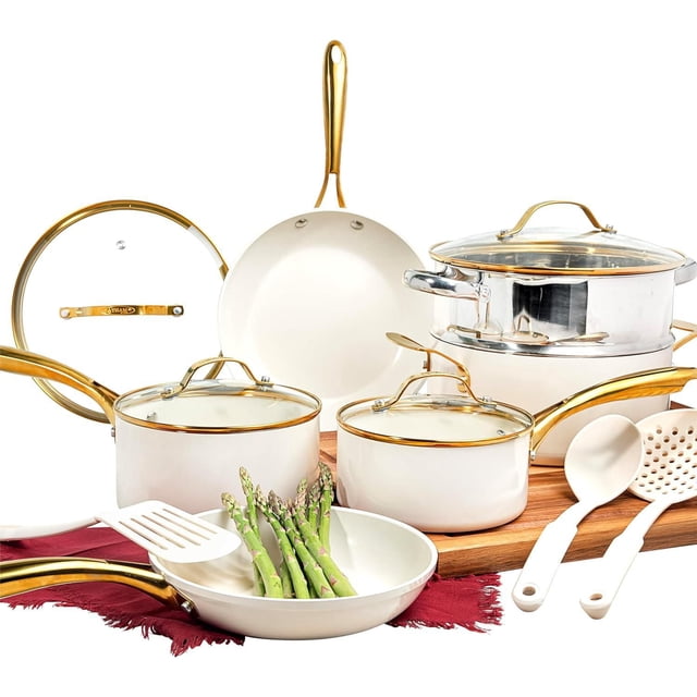 Gotham Steel 15 Pc Ceramic Cookware Set with cream nonstick ceramic pots and pans, gold-tone ergonomic handles, tempered glass lids, and included utensils, shown with fresh asparagus in a frying pan on a wooden surface.