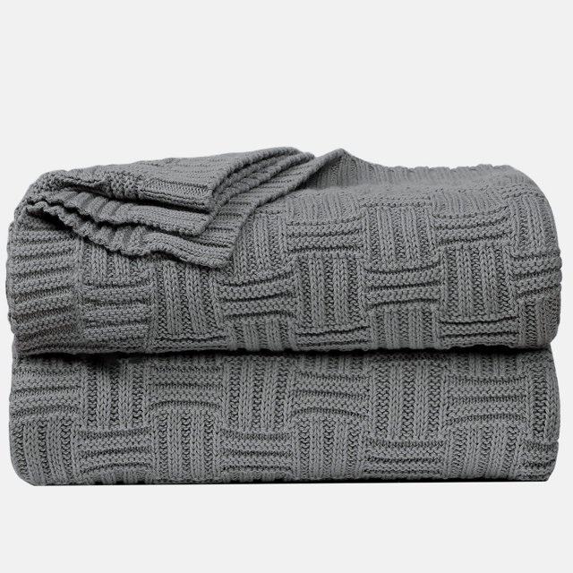 Unique Bargains 100% Cotton Cross Cable Knit Throw Blanket in grey, measuring 47 x 70 inches (120 x 180 cm). The blanket features a modern cross cable knit pattern with a soft and breathable texture. It is lightweight and suitable for use on sofas, couches, beds, or as a travel blanket. The image shows the blanket neatly folded, highlighting its intricate knit design.
