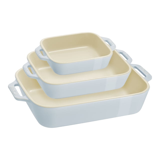 STAUB Ceramique Rectangular Baking Dish Set Macaron Light Blue 3 Piece, featuring three pastel-hued ceramic dishes in small (6 x 4 inches, 0.4 liters), medium (8 x 6 inches, 1.1 liters), and large (11 x 8 inches, 2.4 liters) sizes. Each dish has a light blue exterior with a cream interior and large handles for easy maneuvering. Suitable for oven, microwave, and dishwasher use, and temperature-resistant up to 300°C/572°F.