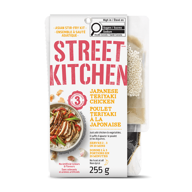 Street Kitchen Kit de Poulet Teriyaki Japonais 255 g Comprenant une Pochette Blanche avec Texte Rouge et Jaune, une suggestion de Portion de Poulet Teriyaki avec des Légumes sur du Riz, et une Pochette Latérale Transparente Montrant des Sachets de Graines de Sésame et de sauce, Conçu pour une Préparation Rapide en 20 Minutes pour Servir 2-3 Personnes Sans Colorants Ni Arômes Artificiels.