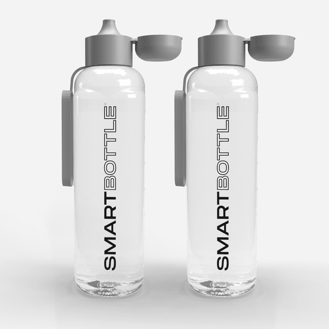Made in Canada, Smartbottle 1L water bottle with carry ring, BPA-free and dishwasher safe, shown in a 2-pack. The bottles feature a grey lid with a flip-top design and a square-shaped body for easy stacking. Lightweight and leak-proof, crafted from shatter-resistant material, suitable for microwave and freezer use. Produced sustainably using solar power, ideal for hiking or commuting.
