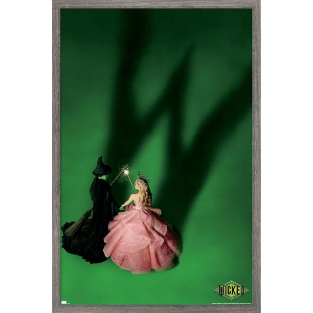 Wicked - Teaser One Sheet Wall Poster, 22.375" x 34" showing a centered view of two figures on a green background; a witch in black cloak and pointed hat holding a broomstick, and a princess in a layered pink gown with a crown holding a sparkling wand, casting a large shadow resembling a hand behind them, with the Wicked logo at the bottom right, ideal for bedroom or office wall decor.