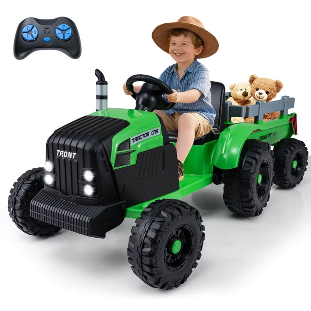 Costway 24V Ride On Tractor for Kids with Detachable Trailer in green, featuring a child seated on the wide seat with a safety belt, driving the tractor. The detachable trailer is loaded with teddy bears, showcasing its cargo capacity. The tractor includes anti-slip wheels, LED headlights, and a simulated chimney for realistic play. A remote control is displayed, highlighting the dual control modes for parents and kids. Designed for children aged 3 to 8, this powered ride-on toy offers speeds of 2 to 3.7 mph and is suitable for various terrains.