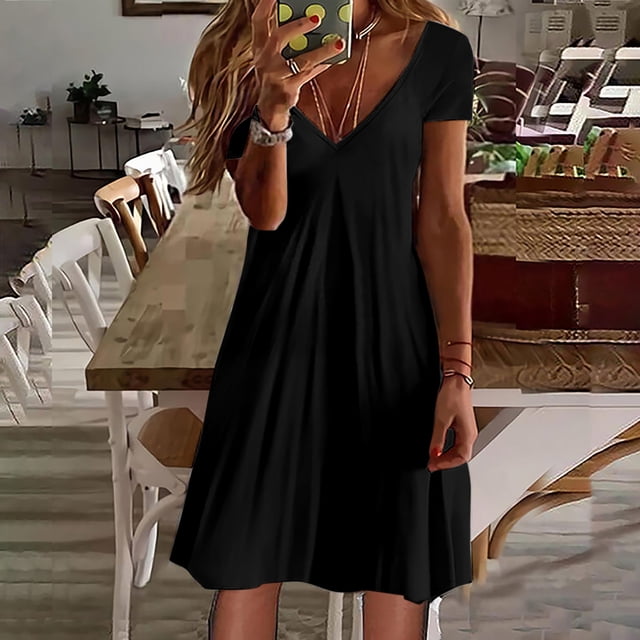 SMihono Robe d'Été pour Femmes Grande Taille Mode Femmes Décontractée Col en V Couleur Unie Ample Élastique Robe à Manches Courtes Jupe. la Robe Est Exposée dans une Couleur Noire Unie avec un Col en V et des Manches Courtes. Elle a une Coupe Ample, Élastique et un Ourlet Longueur Genou, Fabriquée en Tissu polyester Léger pour le Confort. Idéale pour les occasions Décontractées comme le Port Quotidien, les Vacances Ou les Fêtes. le Modèle Est à l'Intérieur dans une Salle à Manger, Accessoirisée avec des bracelets et des Colliers.
