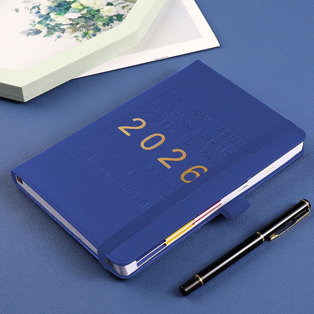 2026 Planner Hardcover Calendar Planner with a durable blue hardcover featuring embossed text and gold '2026' lettering. Includes an elastic strap and pen holder, ideal for monthly, weekly, and daily scheduling. Suitable for office, school, or personal use. Positioned on a blue surface with a black pen nearby.