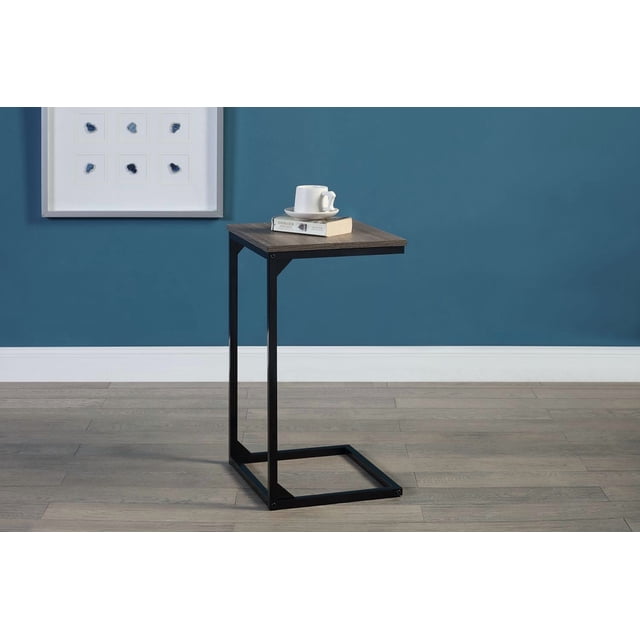 Hometrends C side table with black powder-coated metal frame and wood grain finish top, designed for space-saving versatility in living room furniture, shown front-facing on light wood floor with blue wall background, holding a white cup and book, suitable for small space storage and easy access.