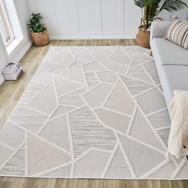 Rug Branch Maison Modern Indoor Area Rug in cream beige with an abstract geometric pattern of textured shapes, placed on light wood flooring in a bright living room with a gray sofa and woven plant baskets, ideal for living rooms, bedrooms, and kitchens.