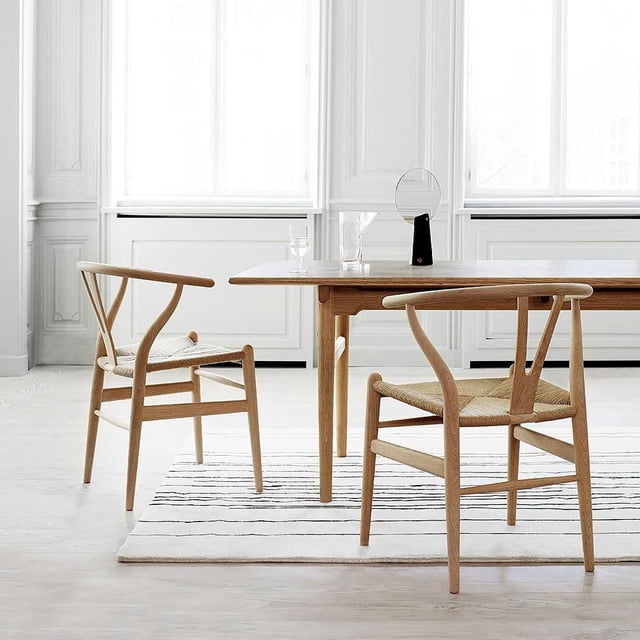 Heavenly Collection Wood Dining Chair SET OF 2 with ash wood frames and beige braided rope seats, arranged around a wooden dining table on a striped rug in a bright minimalist dining room with large windows, suitable for stylish kitchen seating.