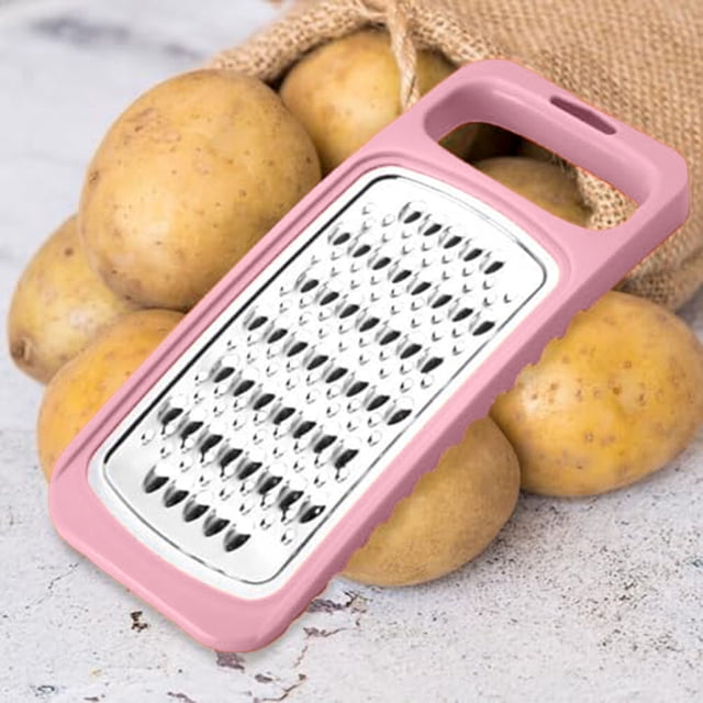 Riforla Râpe à Fromage, Râpes en Acier Inoxydable, Double Râpe à Pommes de Terre, Trancheuse à Carottes, Légumes avec Poignée, Rose. la Râpe Présente une Conception Double Face avec des Lames en Acier Inoxydable Tranchantes pour Râper les Pommes de Terre, Râper le Fromage et Trancher les Légumes. Elle a une Poignée Rose pour une Prise Facile et Est Montrée Placée sur une surface avec des Pommes de Terre en Arrière-Plan.
